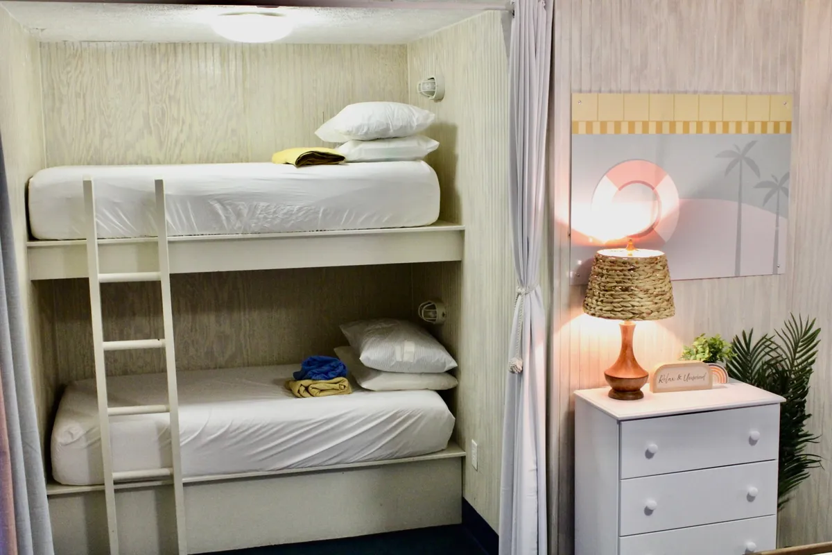 A welcoming bedroom scene highlights a set of bunk beds, a softly lit table lamp, and a nightstand. The space feels casual and family-oriented, perfect for unwinding after a day exploring the neighborhood.